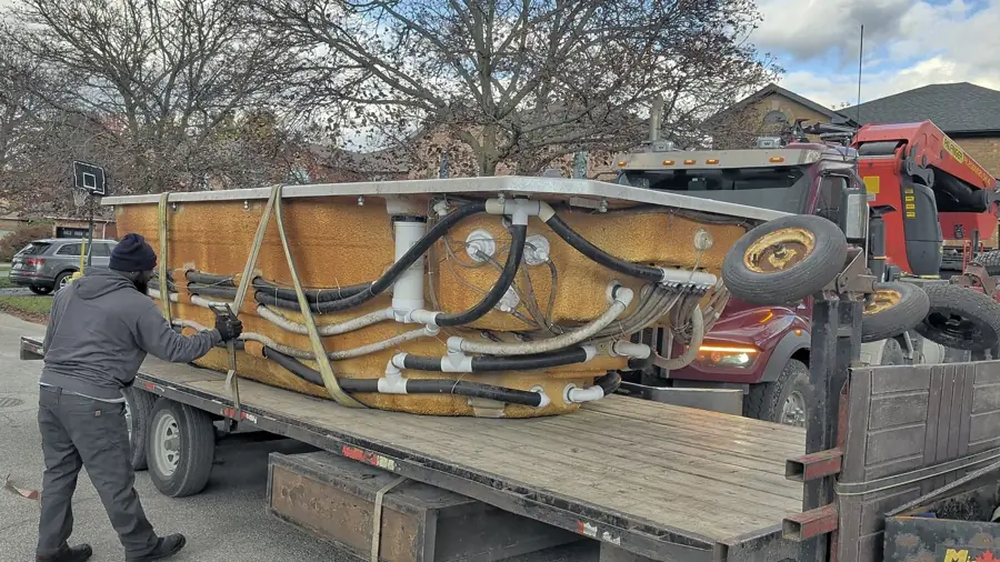 Crew loading a hot tub onto the trailer in Barrie