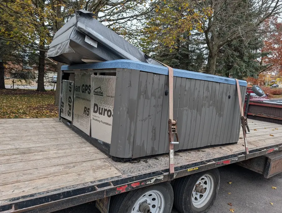 Old hot tub strapped to a deckover trailer for disposal in Stouffville